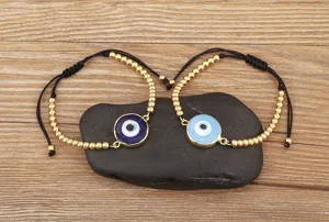 Vue détaillée de bracelets réglables avec mauvais œil et perles dorées sur pierre.