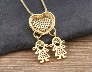 Close-up detail of 18k gold plated heart necklace with double girl pendant, sparkling zirconia.