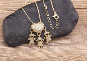 Close-up detail shot of the gold-plated rhinestone family pendant necklace on pebble.