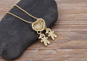 Close-up detail of 18k gold plated heart necklace with cute double child charms and shiny zirconia stones.