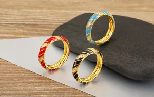 Vista detallada de anillos de esmalte colorido con patrón en espiral y circonitas.