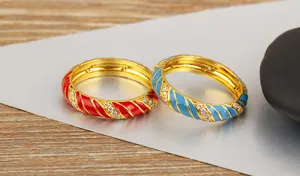 Primer plano de anillos esmaltados de rayas en espiral coloridas con circonitas microengastadas.