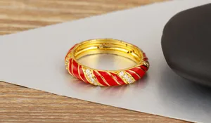 Vista detallada del anillo de espiral de esmalte rojo chapado en oro de 18k con circonitas micro.