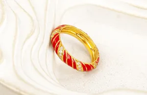 Anillo bañado en oro con rayas espirales de esmalte rojo y circonita para estilo de lujo.