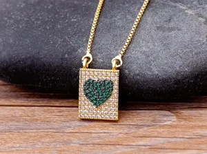 Gros plan sur le collier en cuivre plaqué or avec un pendentif cœur en zircon vert.