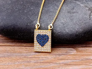 Gros plan du collier de chaîne dorée avec pendentif cœur en zircone cubique bleu et blanc