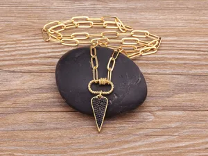 Dettaglio in primo piano della collana con catena graffetta dorata e pendente cuore.