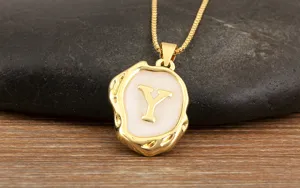 Gold-plated initial Y pendant necklace, close-up of white enamel and irregular geometric shape.