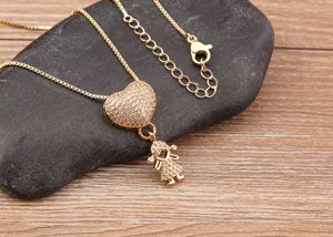 Exquisite gold-tone clavicle necklace featuring a pavé heart pendant and a cute girl charm.