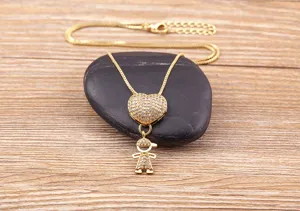 Detail shot of the gold heart and boy pendant necklace, showcasing sparkling crystal design.