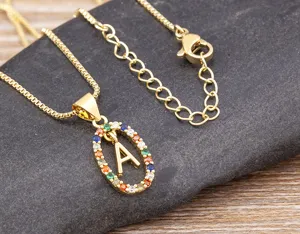 Gold letter necklace pendant with colorful cubic zirconia stones, detailed shot of fashion jewelry.