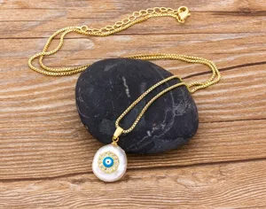 Gold evil eye pendant necklace with baroque pearl and sparkling zircon details, fine chain.