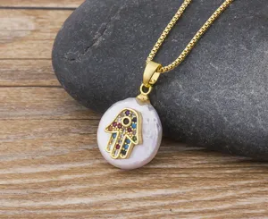 Detailed close-up view of baroque pearl Hamsa hand necklace with colorful evil eye zircon charms.