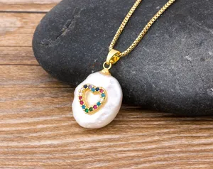 Close-up detail of the baroque pearl necklace featuring a colorful zircon heart pendant.