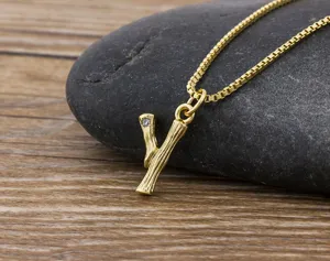 Gold-plated letter Y initial pendant necklace with branch texture and sparkling crystal detail.
