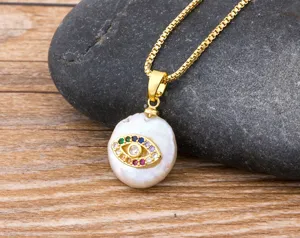 Detail shot of baroque pearl evil eye pendant necklace with colorful zirconia on gold chain.
