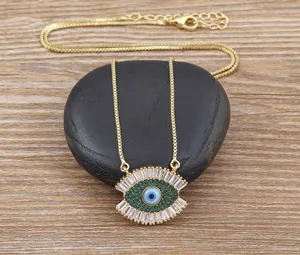 Detailed close-up of a stunning evil eye pendant necklace with sparkling green and clear stones.
