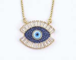 Evil eye pendant necklace close-up, gold-tone box chain with sparkling blue and white crystal stones detail.