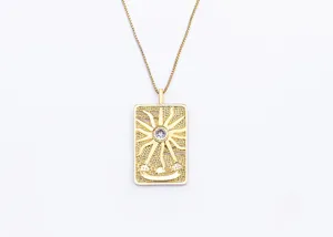 Gold tarot card pendant necklace detail close-up showing intricate sun motif and sparkling zirconia.