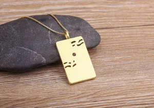Close-up detail view of the gold square pendant necklace with delicate hollow cutout patterns.