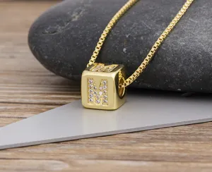 Detailed close-up of a gold-plated cubic letter M pendant necklace with cubic zirconia.