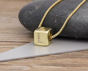 Gold-plated cube letter L pendant necklace with sparkling cubic zirconia stones. Detail view.