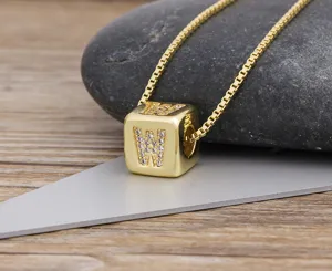Close-up detail of the gold-plated cubic letter pendant with sparkling zirconia stones.