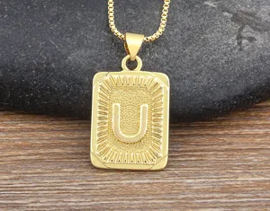 Close-up detail of the gold stainless steel letter U pendant necklace with box chain.