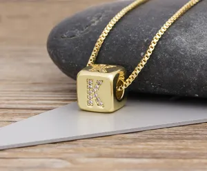 Close-up of gold-plated cubic letter pendant necklace with sparkling zirconia on stone.