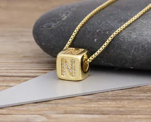 Gold-plated cubic zirconia letter N pendant necklace, delicate square chain jewelry detail shot.