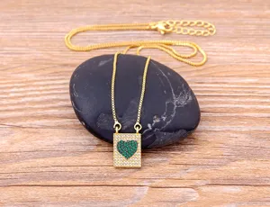 Gros plan détaillé d'un collier doré élégant avec pendentif cœur pavé de zircone rectangulaire.