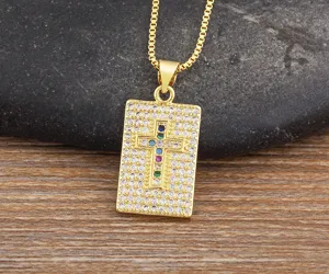 Gold plated rectangular cross pendant necklace with colorful stones detail shot.
