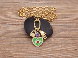 Collana a maglie grosse placcata in oro con occhio malvagio e ciondolo a cuore verde.
