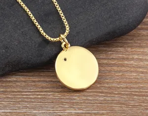 Close-up of a minimalist 18k gold plated round pendant necklace with a tiny zircon detail.