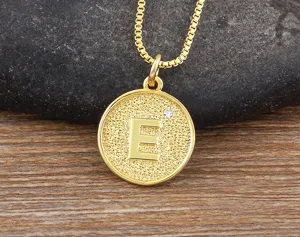 Close-up detail of the elegant gold-plated letter E pendant necklace with sparkling cubic zirconia.