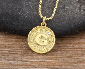 Gold initial letter G pendant necklace, round coin charm with sparkling zircon crystal details.