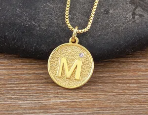 Close-up detail of the 18k gold plated letter M pendant necklace with sparkling cubic zirconia.