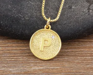 Close-up view of the 18k gold-plated round pendant necklace featuring textured surface and letter P.