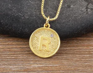 Close-up detail of the 18k gold plated letter R pendant necklace with sparkling zircon stone.