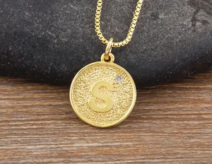 Close-up of a gold-plated letter S pendant necklace with shimmering zircon detail.
