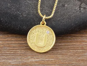 Gold plated initial U pendant necklace with sparkling cubic zirconia, elegant detail shot.