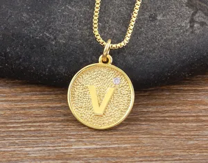 Detailed closeup of 18k gold plated copper letter V pendant necklace with sparkling zircon.