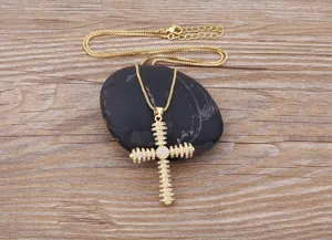 Detailed view of gold plated cross pendant necklace adorned with cubic zirconia stones.