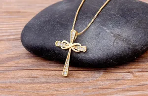 Detailed shot of a gold-plated cross pendant necklace sparkling with cubic zirconia stones.