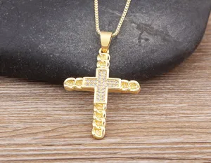 Close-up of gold-plated cross pendant necklace with sparkling cubic zirconia stones details.