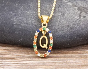 Gold-plated letter Q pendant necklace with colorful cubic zirconia stones in detail shot.