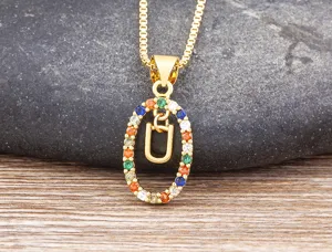 Gold-plated necklace detailed close-up featuring multi-color zircon oval pendant and letter U.