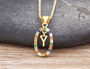Close-up of gold-plated pendant necklace featuring colorful cubic zirconia and letter Y.