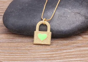Gros plan détaillé d'un collier pendentif cadenas cœur doré avec un bel émail vert.
