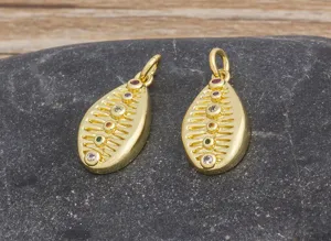 Close-up details of gold-plated shell shaped pendants featuring colorful cubic zirconia stones.